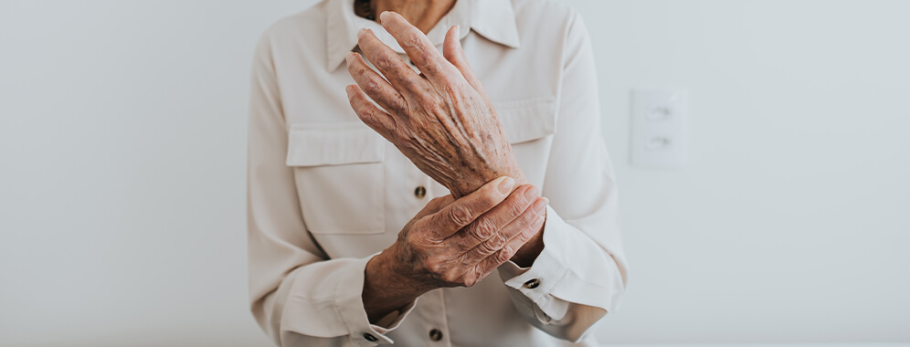 Eine ältere Person hält sich das Handgelenk.