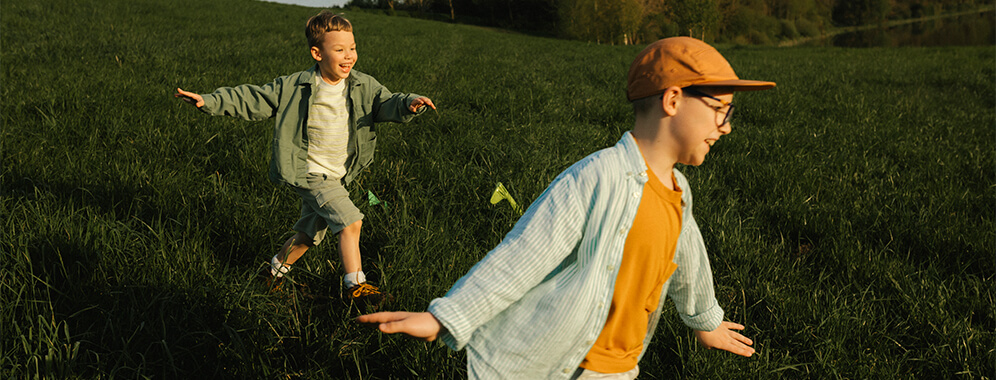 Zwei Jungen laufen über eine Wiese. 