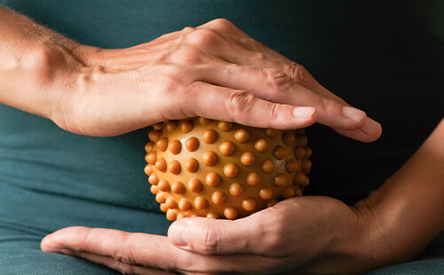 Eine Hand bewegt einen Igelball.