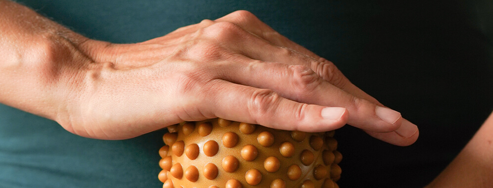 Eine Hand bewegt einen Igelball.