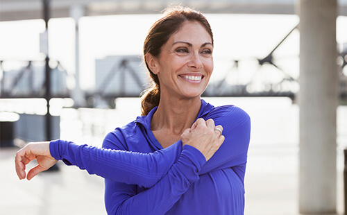 Eine Frau dehnt ihre Schulter.