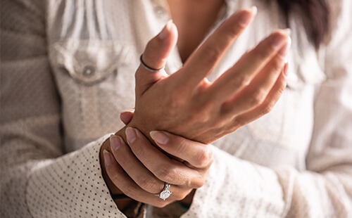 Eine Frau hält ihr Handgelenk.