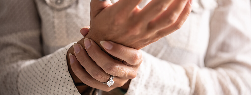 Eine Frau hält ihr Handgelenk.