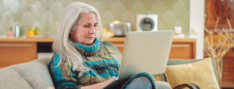 Eine Frau mit Laptop auf der Couch. 