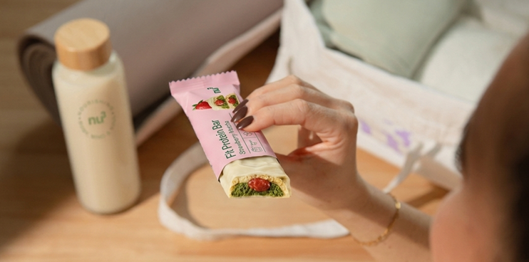 Frau mit Shop Apotheke Paket und nu3 Produkt in der Hand