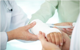 Ärzte verbinden Arm eines Patienten. Verbandmaterial sichtbar.