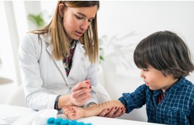 Arzt untersucht Kind. Arzt und Kind im Büro. Hauttest.