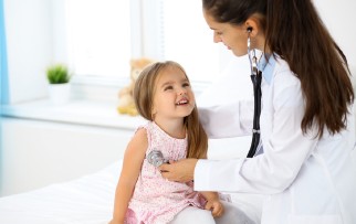 Ärztin untersucht ein Kind mit einem Stethoskop.