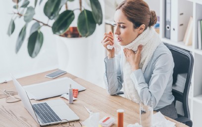Frau am Schreibtisch, Taschentücher, Husten, Laptop, Erkältungssymptome.