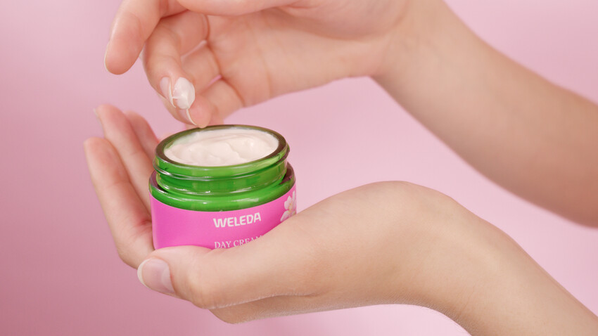 Hände halten Tiegel. Creme wird entnommen. Aufschrift: WELEDA DAY CREAM.