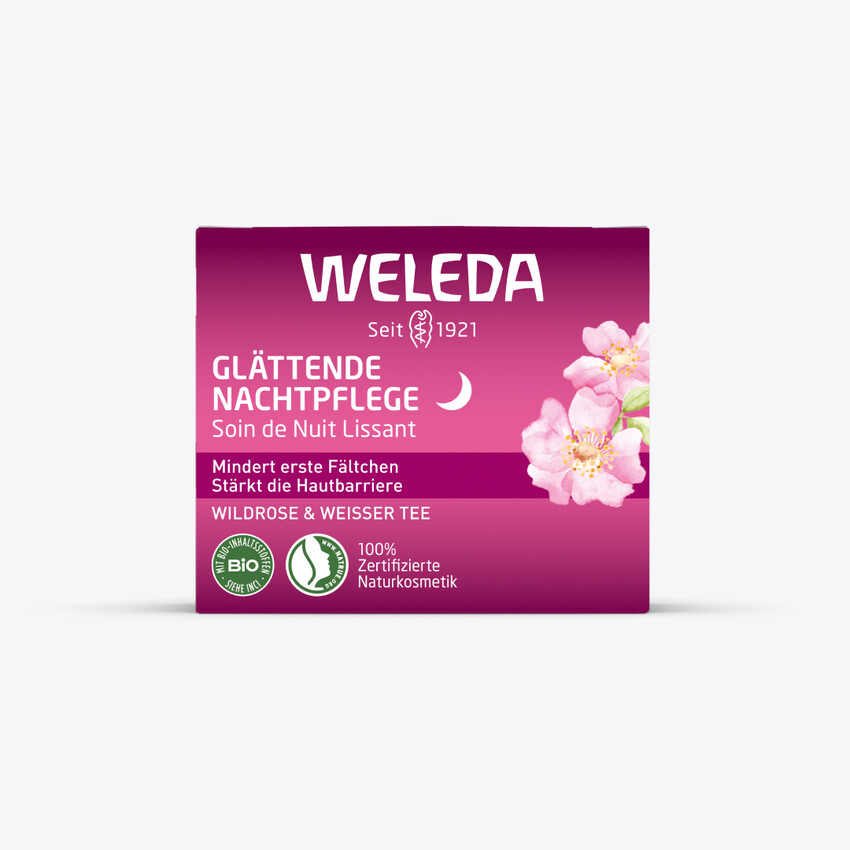 Verpackung. Weleda Glättende Nachtpflege. Rosa Verpackung, Text und Logo. Wildrose & Weißer Tee.