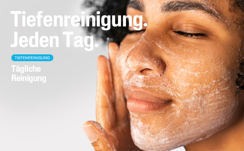 Nahaufnahme einer Frau, die ihr Gesicht mit einer weißen Reinigungslotion einreibt. Text: Tiefenreinigung. Jeden Tag.