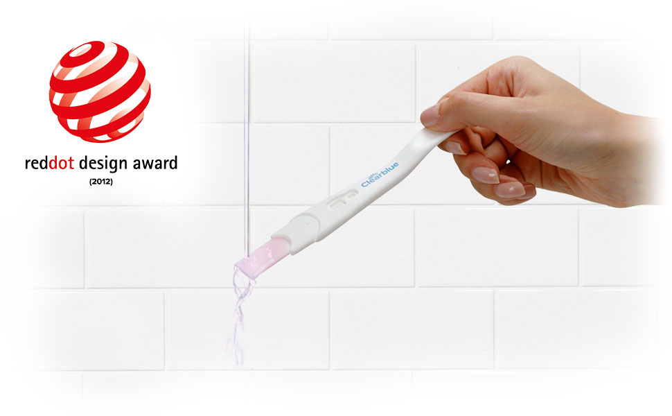Clearblue Schwangerschaftstest wird in die Hand gehalten. Roter Punkt auf dem Test. Reddot Design Award.