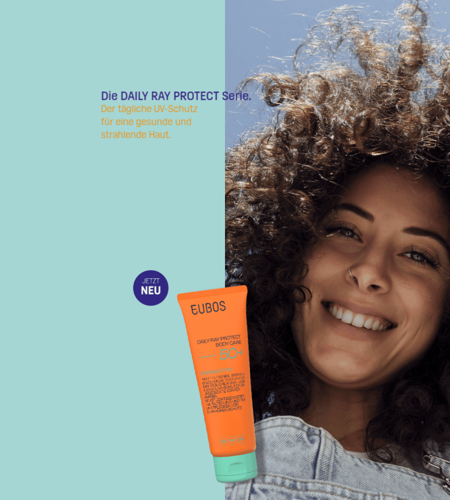 Frau lächelt. EUBOS Daily Ray Protect Body Care LSF 50+ Tube. Text auf blauem Hintergrund.