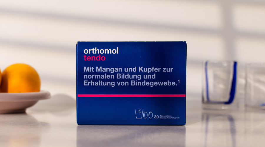 Schachtel orthomol tendo auf Tisch. Text: Mit Mangan und Kupfer zur normalen Bildung... 30 Tagesportionen.