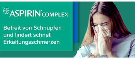 Frau putzt sich die Nase mit einem Taschentuch. Text: Befreit von Schnupfen und lindert schnell Erkältungsschmerzen.